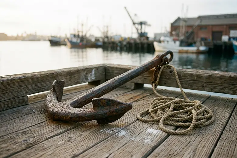 Why Is My WordPress Site So Slow? A heavy weathered iron anchor resting on the wooden planks of a harbour dock