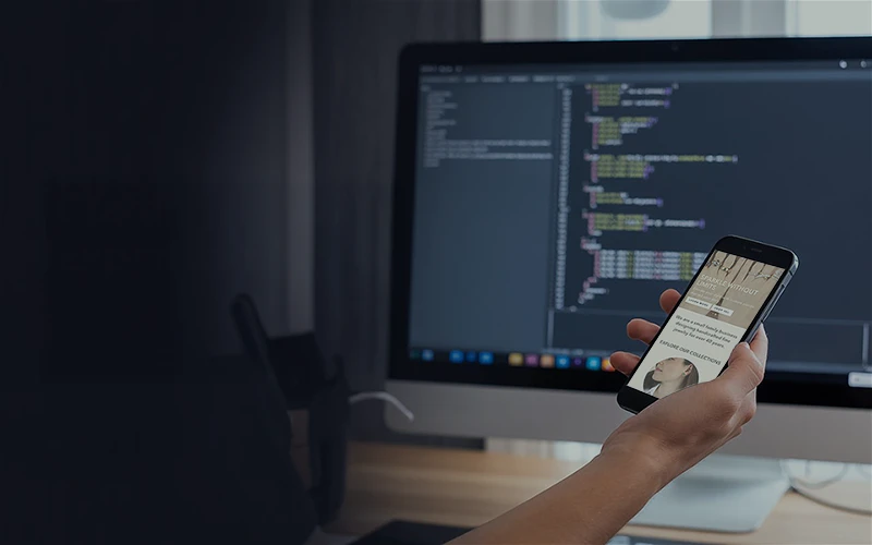 Top view of someone holding an phone next to laptop